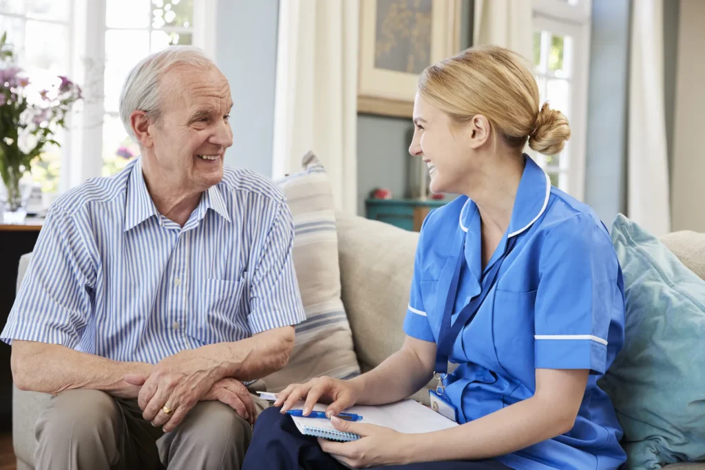 elderly man talking with nurse to resolve challenges of elderly parent care