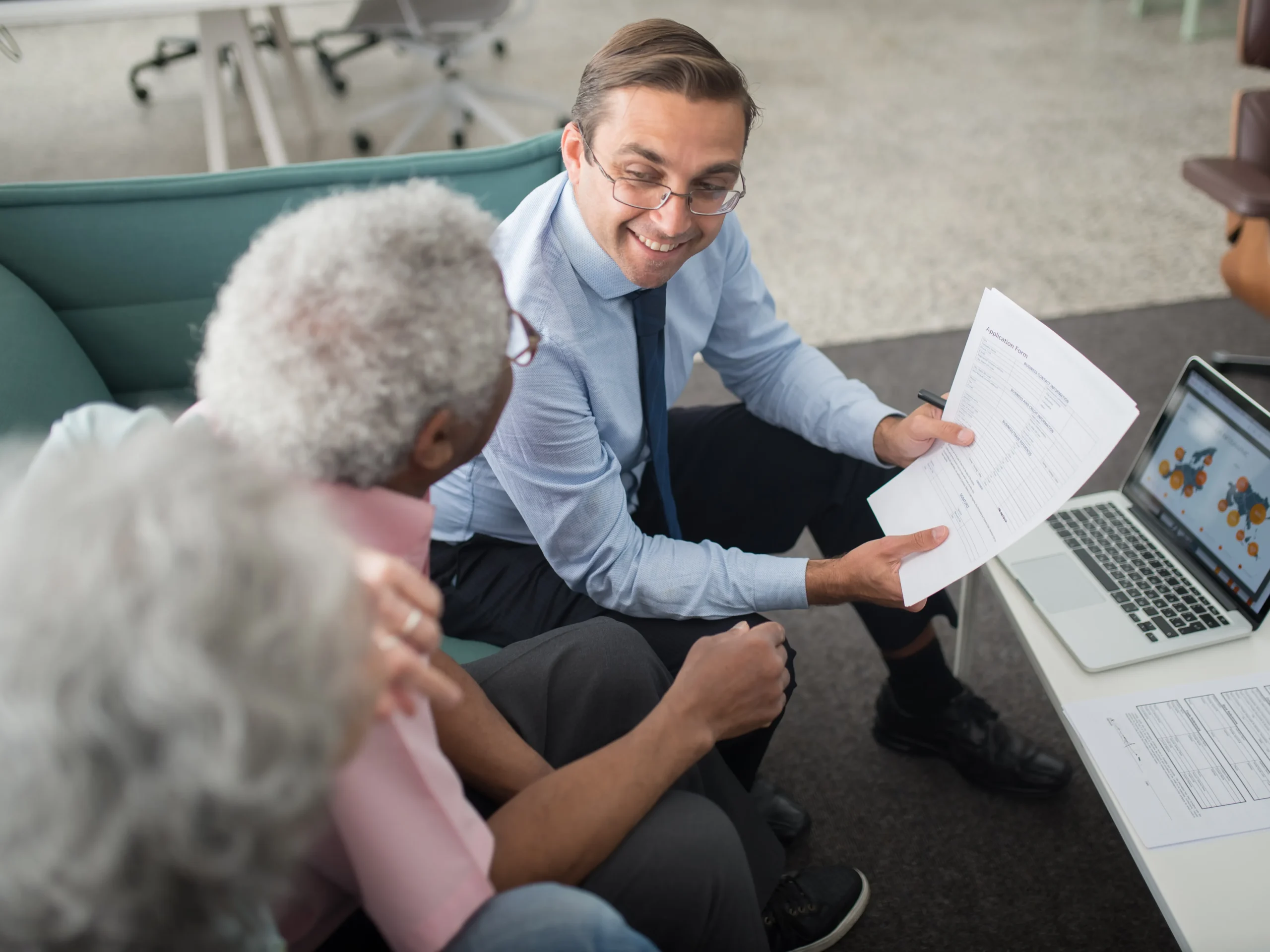 man teaching elderly couple the advantages of in-home care insurance