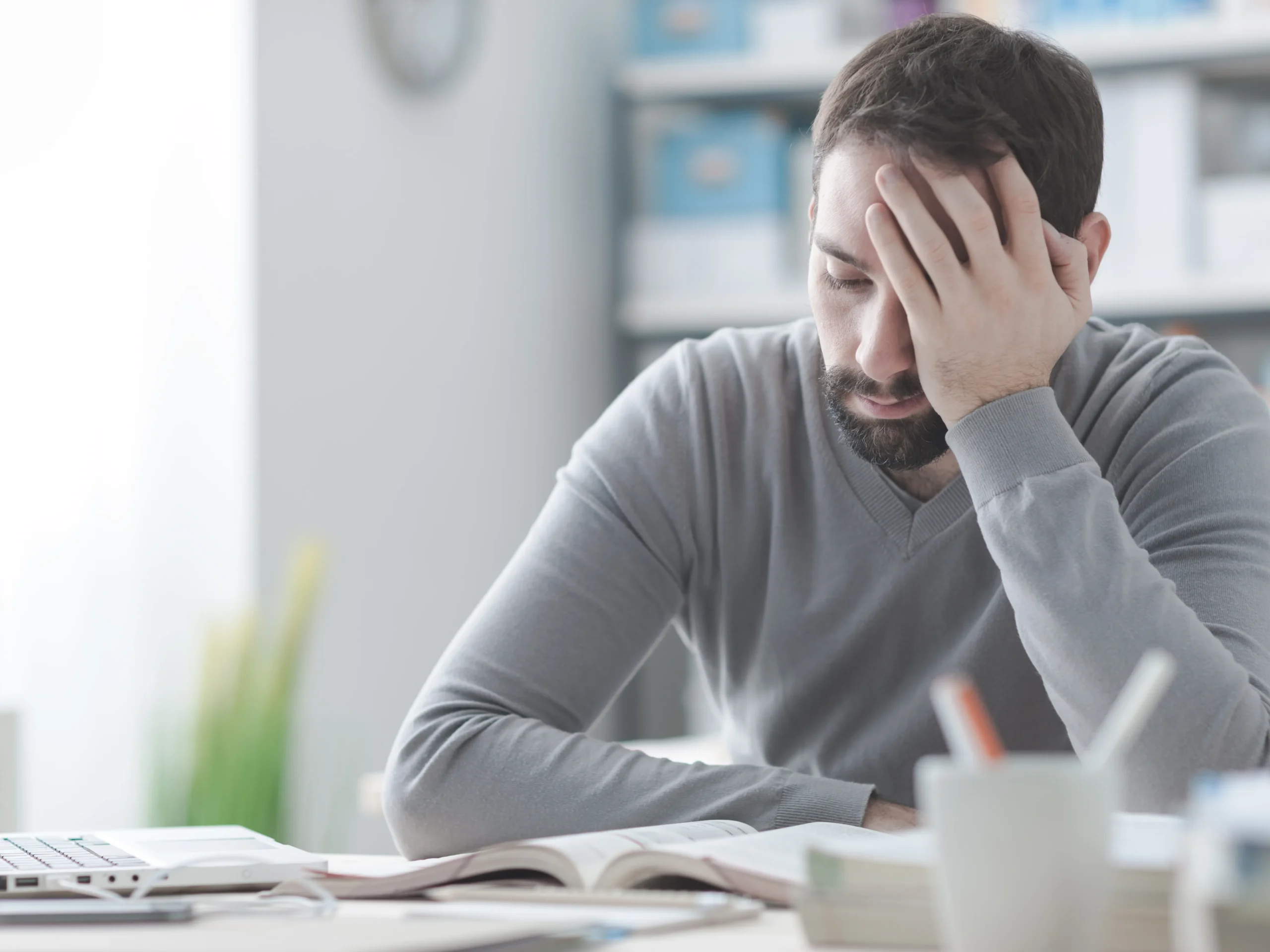 man sitting with palm on hand - stressed